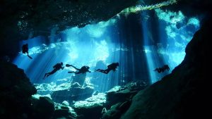 five divers in a cavern