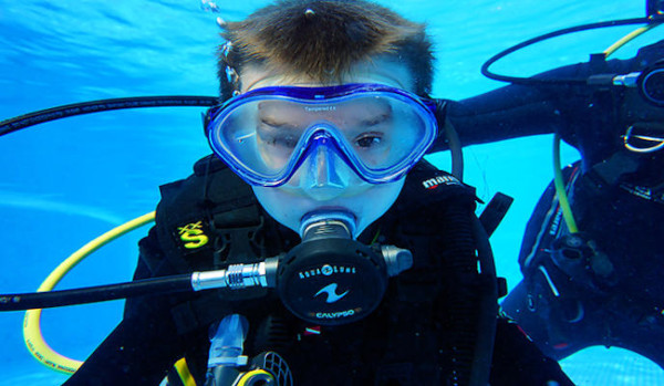 Niño buceando con instructor