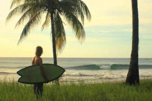 Playa-Avellanas-surfer-carrying-a-board