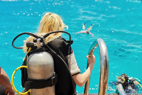 Tanque de buceo: Mujer cargando su tanque de buceo