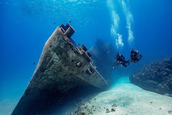 2 buzos explorando barco hundido