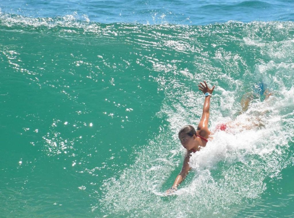 mujer surfeando con el estilo de surf llamado body surfing