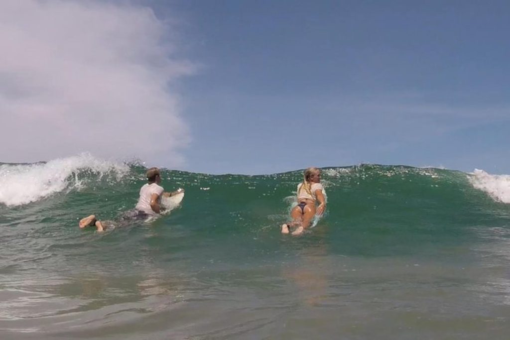 pareja de surfistas esperando por una buena ola