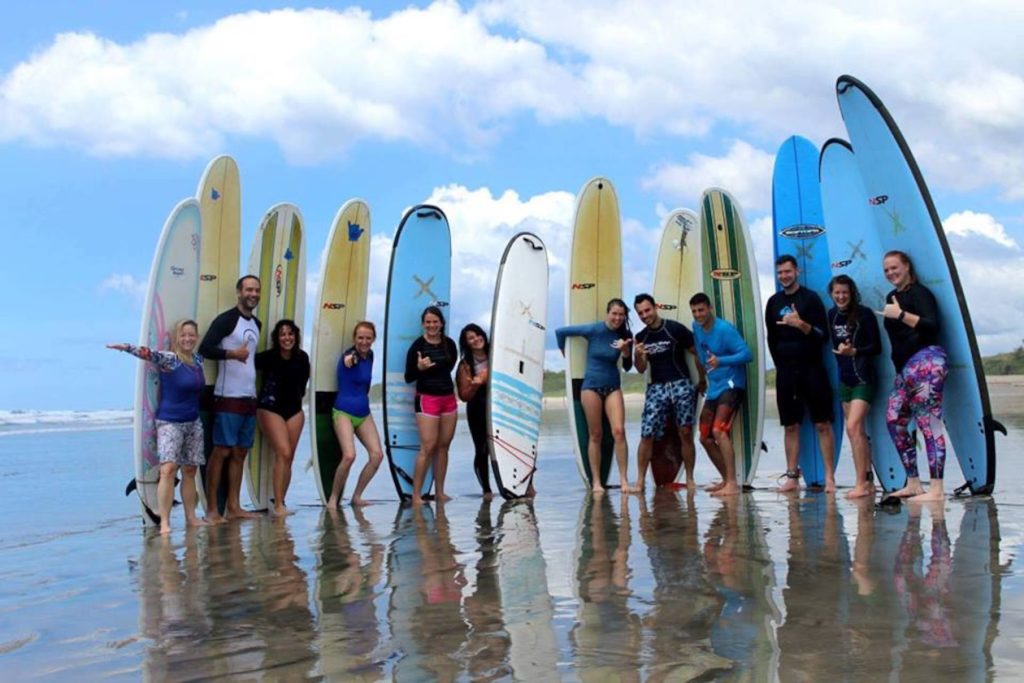 group of surfers holding surfboards on the beach of Nosara-learning to surf or just practicing