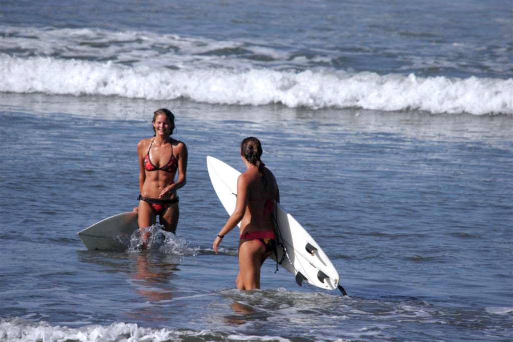 two girls carrying their surfboards