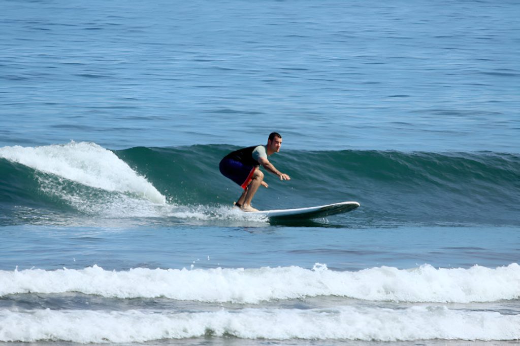 mejores sitios de surf Costa Rica-Un hombre surfeando sobre su tabla en Dominical