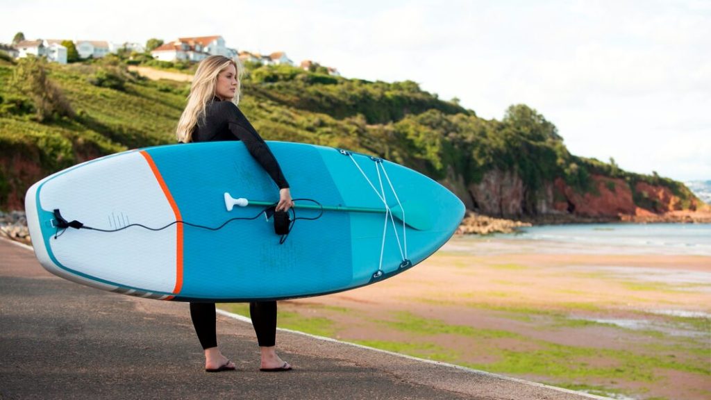 Surfista susteniendo su tabla, en proceso de leer las olas