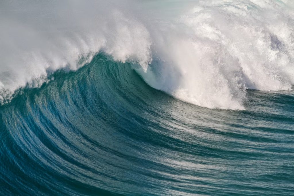 A large wave breaking over the top of a wave