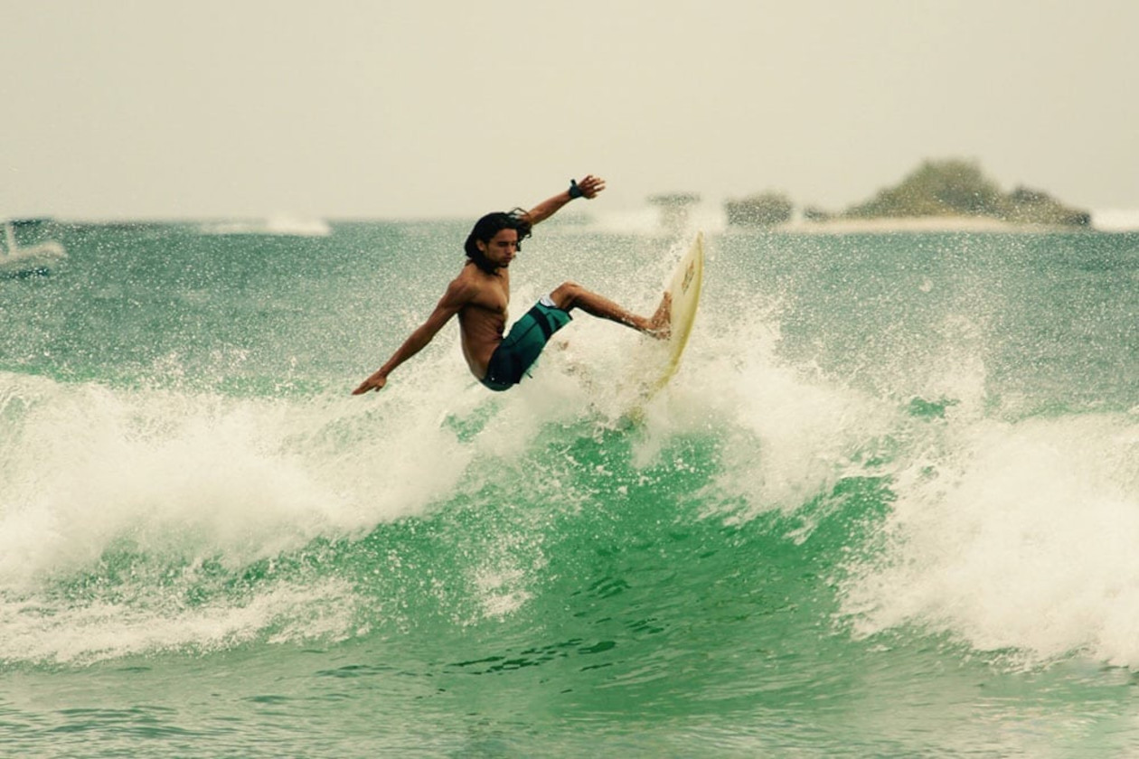 hombre surfeando y haciendo emocionantes maniobras con su tabla de surf