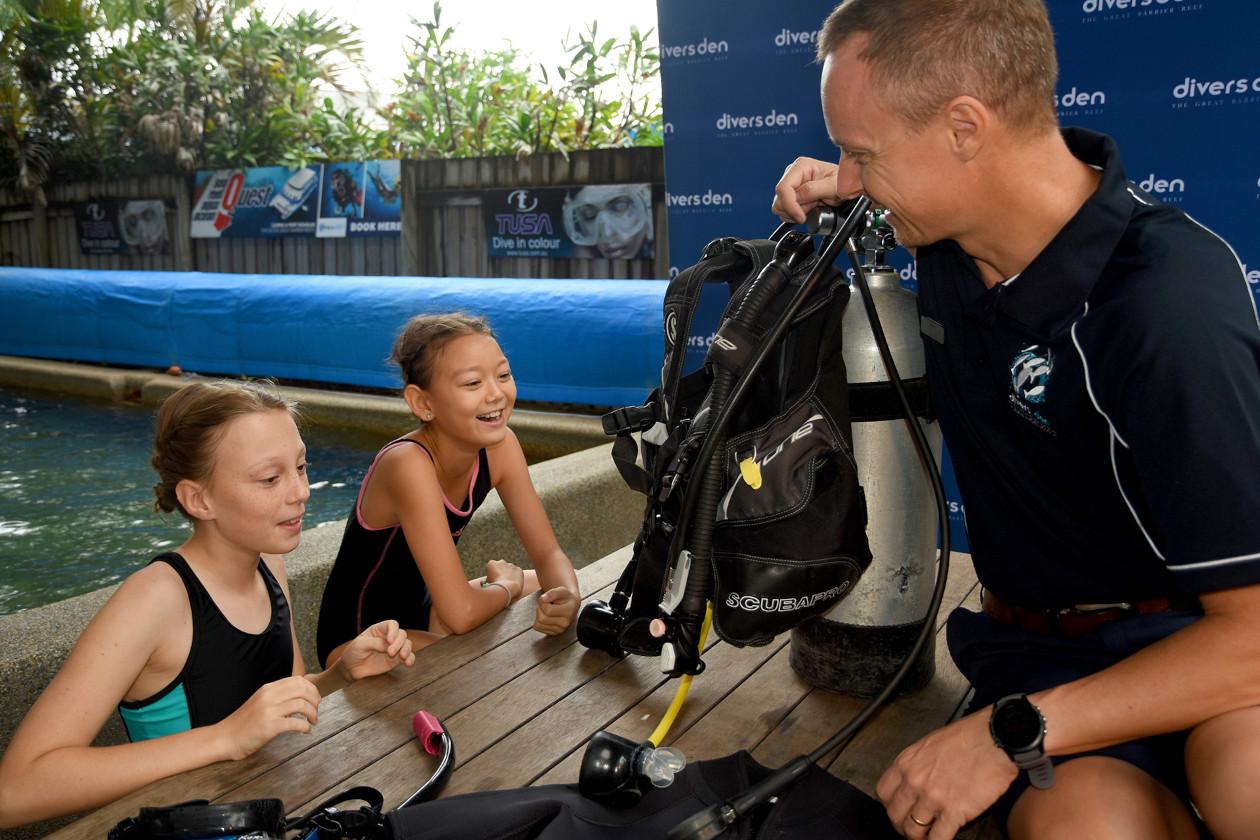 Instructor de buceo capacitando a niñas pequeñas para el buceo